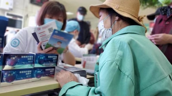 【風(fēng)零+痛風(fēng)日活動現(xiàn)場  醫(yī)務(wù)工作者向市民發(fā)放并講解患者健康手冊等資料】